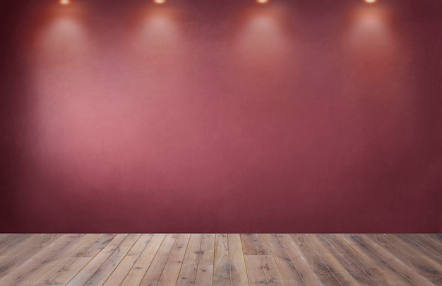 Красная стена с рядом прожекторов в пустой комнате