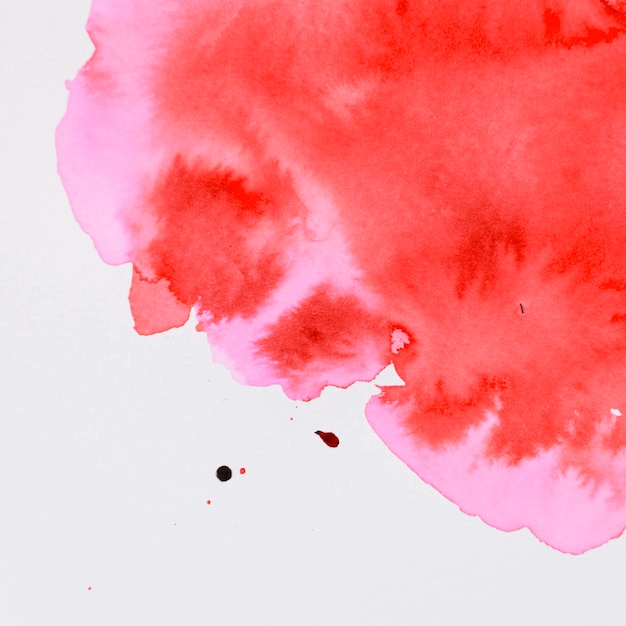 Бесплатное фото Красная акварельная краска течет на белом фоне