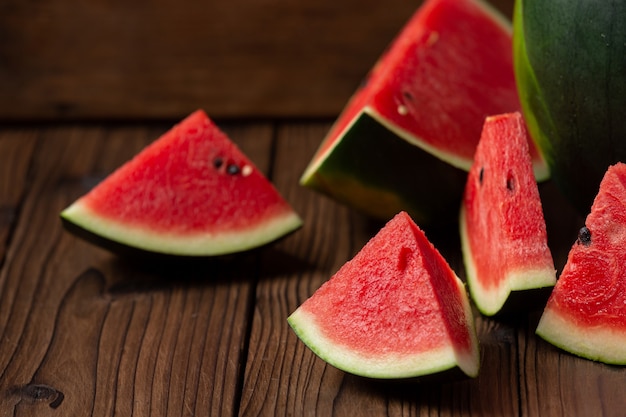 Red watermelon slice on wood background