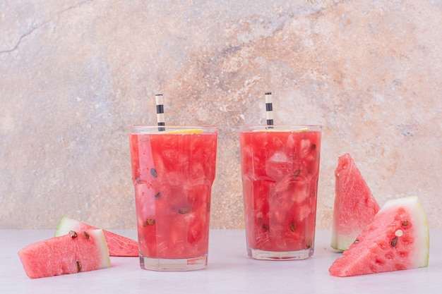 Red watermelon slices with two glasses of juice