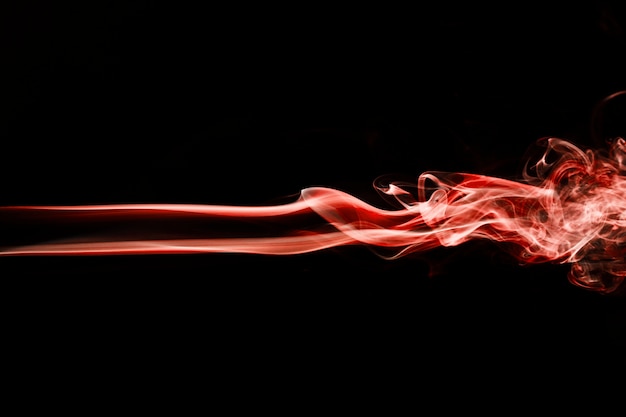 Foto gratuita fumo ondulato rosso su sfondo nero