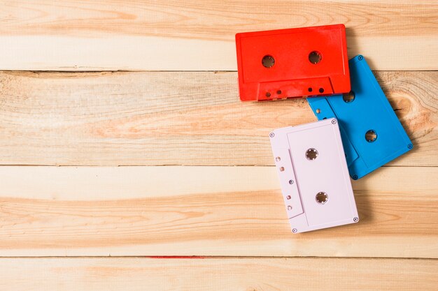 Red; white and blue audio cassette tape on wooden table