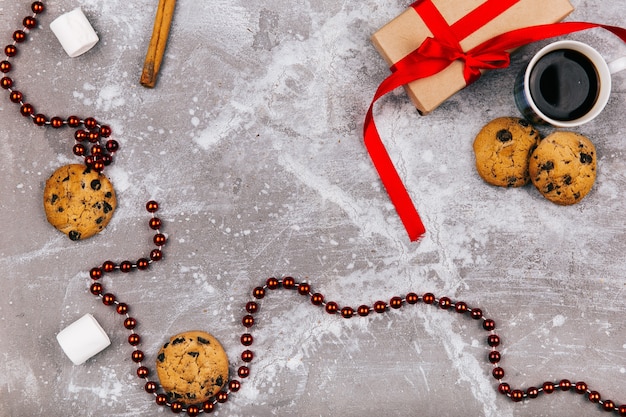 회색 바닥에 빨간색 흰색 사탕, 쿠키, 마시맬로, 커피 한잔 및 선물 상자 거짓말