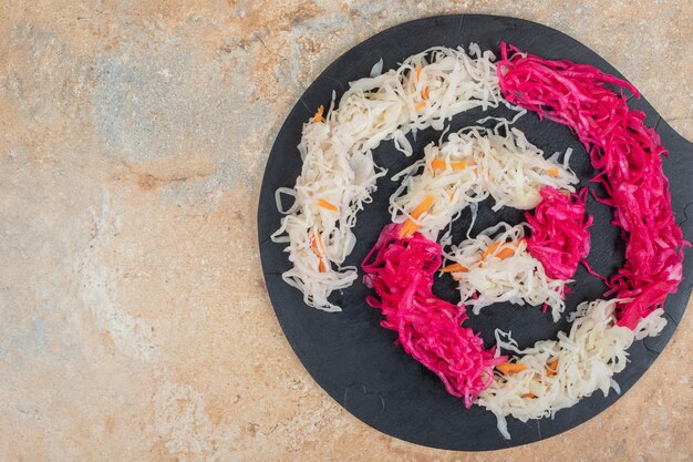 Red and white sauerkraut on black board