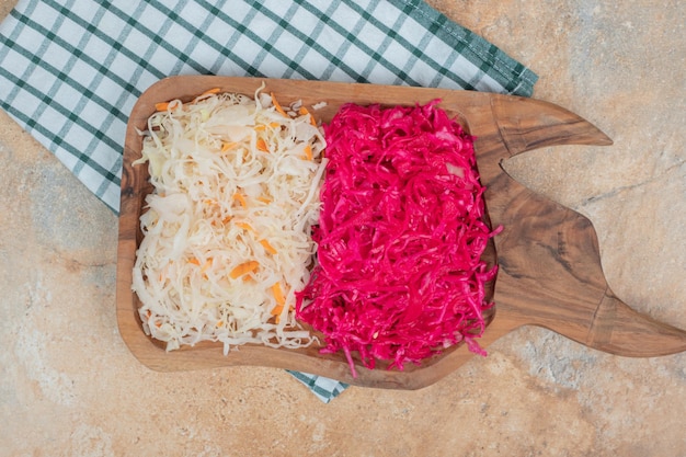 Red and white sauerkraut on wooden board