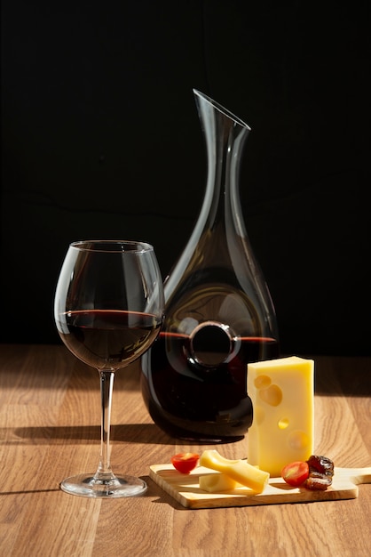 Free photo red wine carafe and cheese arrangement