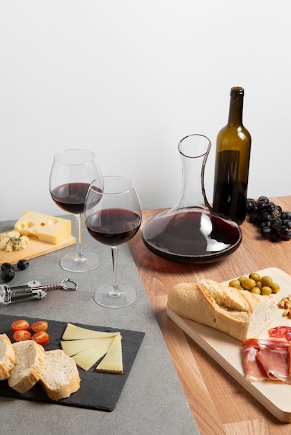 Red wine carafe and snacks on table high angle