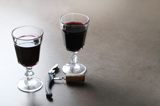 Красное вино в бокалах и штопор