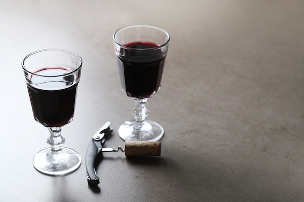 Red wine in glasses and corkscrew