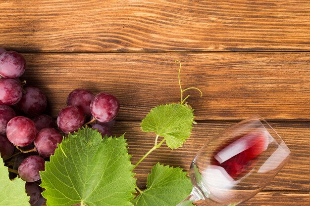 Red wine and grapes on wooden table