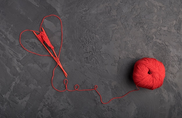 Red wool yarn on slate background