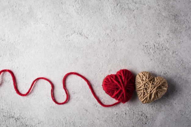 Red yarn heart shaped on the wall background