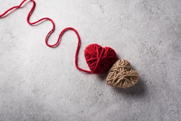 Red yarn heart shaped on the wall background