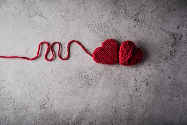 Red yarn heart shaped on the wall background