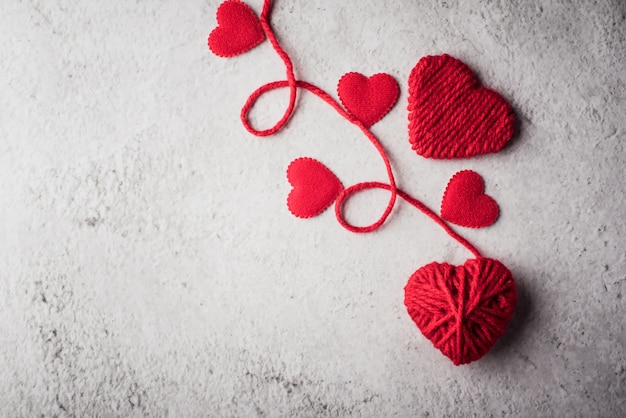 Red yarn heart shaped on the wall background