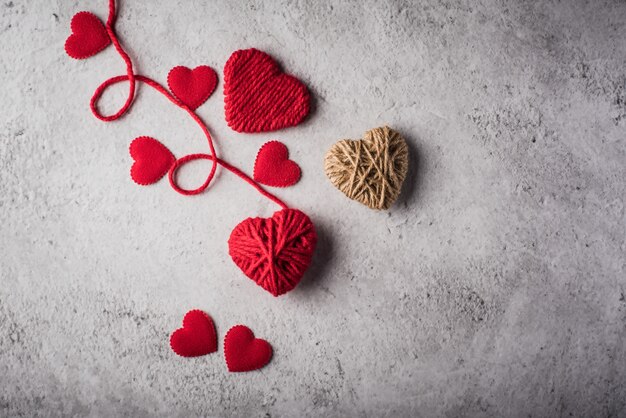 Red yarn heart shaped on the wall background