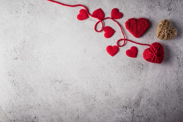 Red yarn heart shaped on the wall background