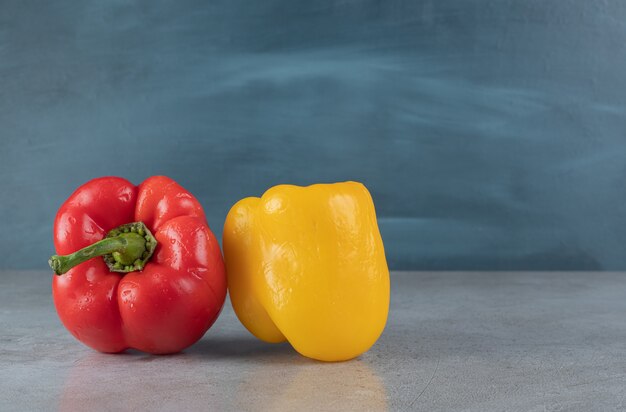 Red and yellow bell peppers on a gray background. High quality photo