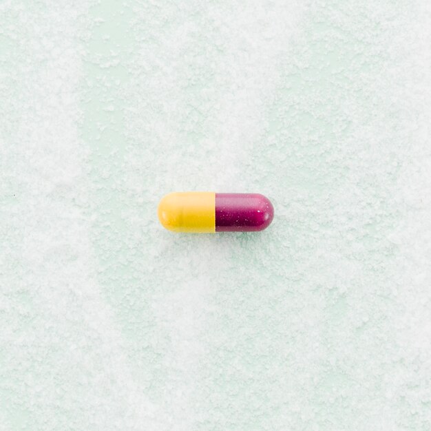 Red and yellow capsules on textured backdrop