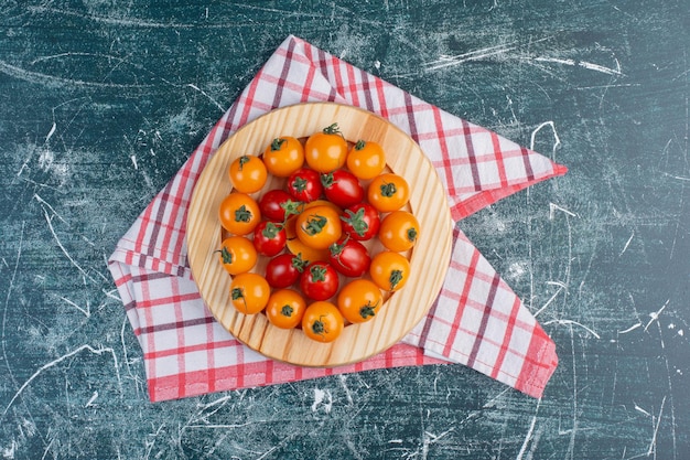 Free photo red and yellow cherry tomatoes on blue surface.