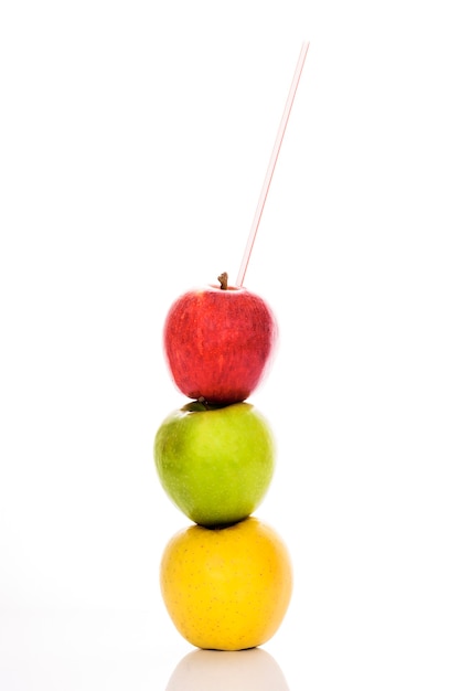 Red, yellow and green apples with straw