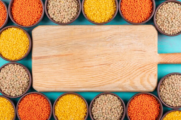 Red and yellow lentils in a bowls with wooden cutting board