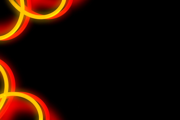 Red and yellow neon curved design on black background