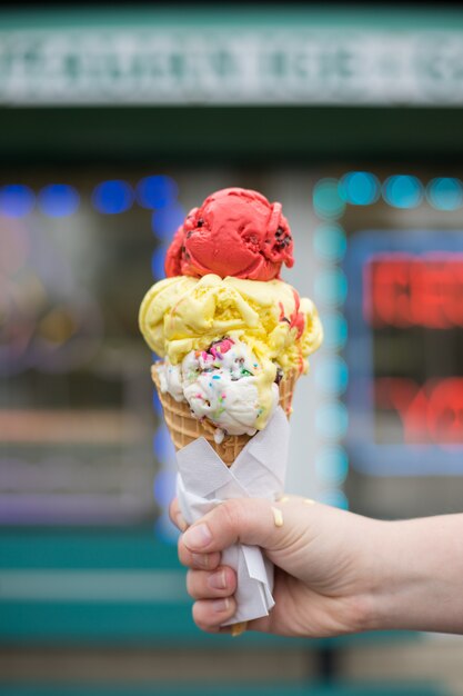 red, yellow, and white ice cream on a cone