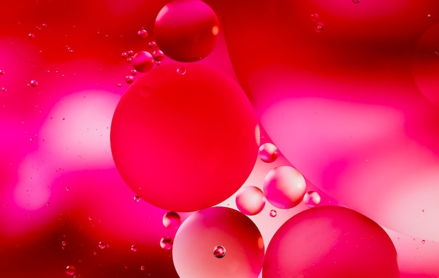 물 표면에 기름 방울의 붉은 색조 추상적 인 배경