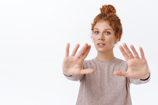 redhead beautiful woman with curly combed hair, pulling arms forward and gazing at front