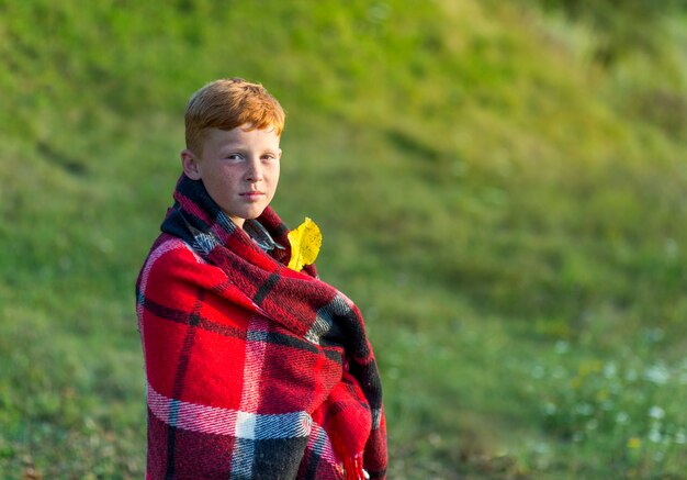 Redhead boy covered with blanket
