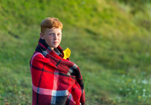 Redhead boy covered with blanket