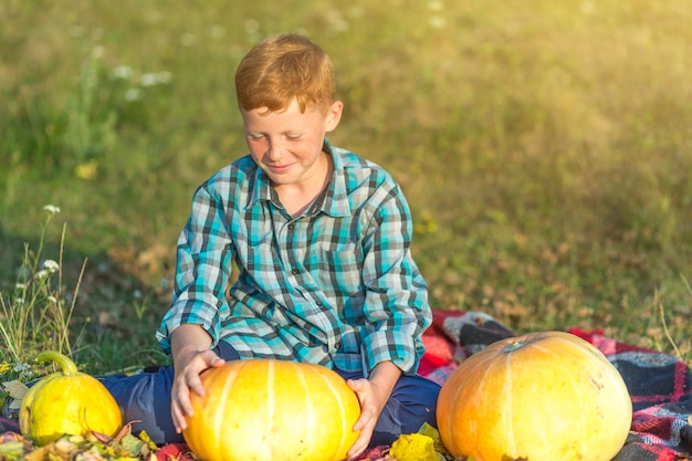 Redhead boy holding a yellow pumpkin 