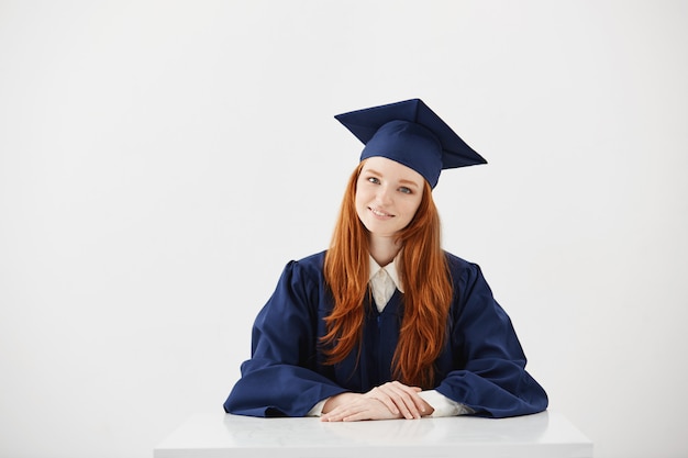 赤毛の女性の大学院が笑っています。