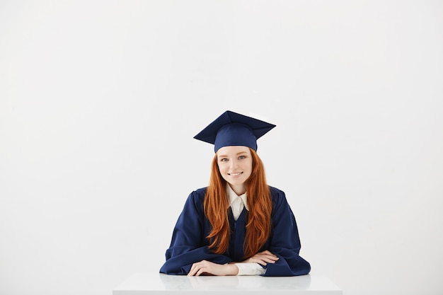 Redhead female graduate smiling.