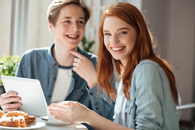 カフェでカメラを探している赤毛の女子学生