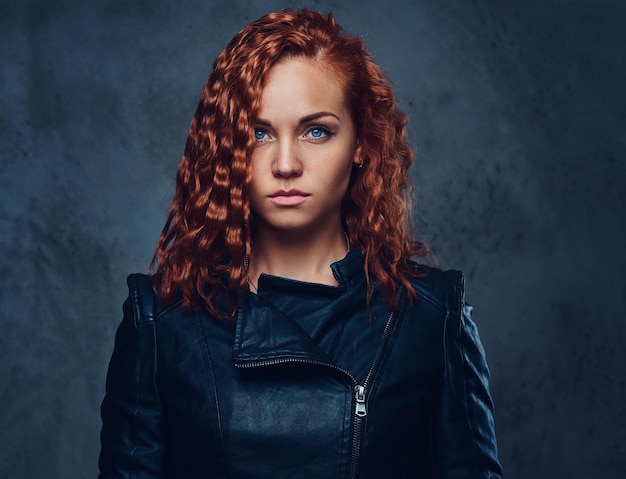 Free photo redhead female supervisor dressed in an elegant suit over grey background.