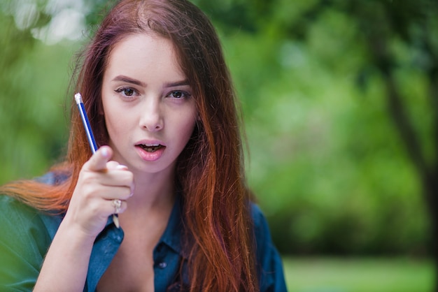 Redhead girl with open mouth pointing