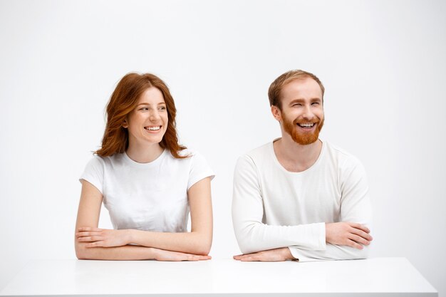 Redhead man and woman laughing over table