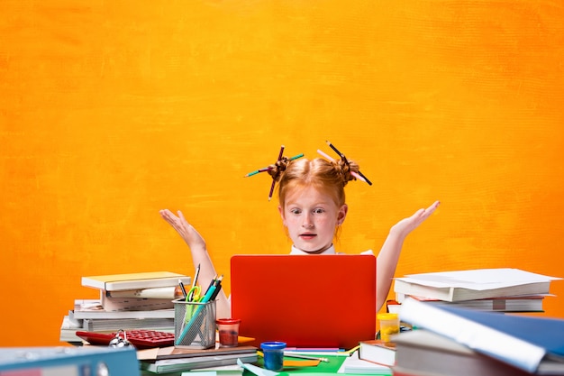 La ragazza adolescente redhead con molti libri a casa. studio girato