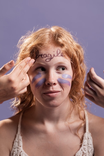 Redhead woman covered with paint and words as a sign of triumph