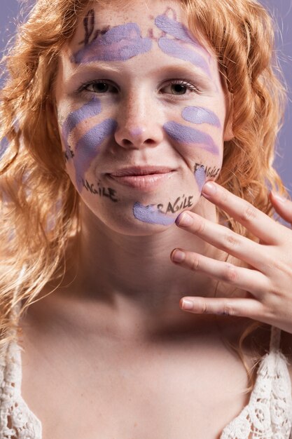 Redhead woman covering words with paint