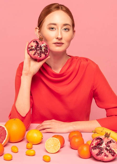 Foto gratuita donna della testarossa che tiene un melograno