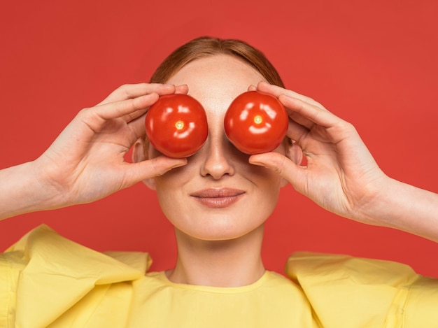 Pomodori della holding della donna della testarossa