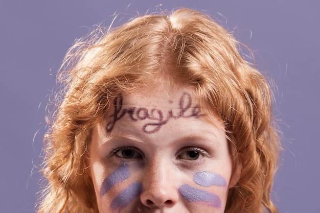 Free photo redhead woman posing while being covered with dismissive words and paint