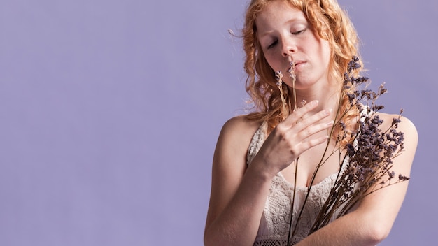 Foto gratuita donna della testarossa che posa con lo spazio della copia e della lavanda