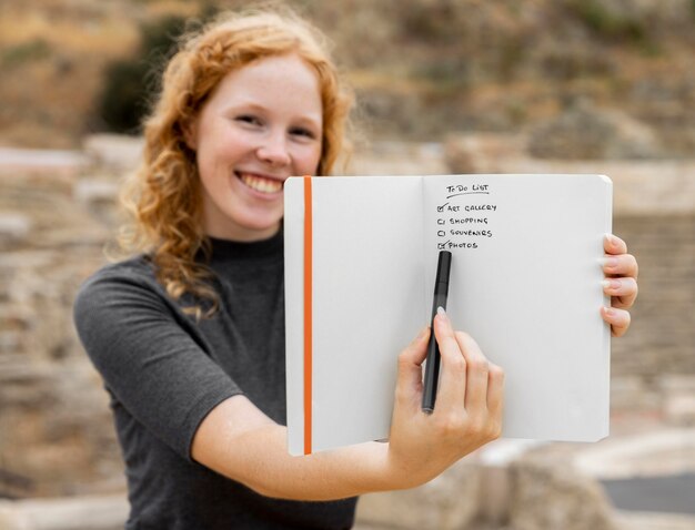 Redhead woman showing journal