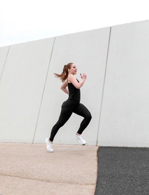 屋外で運動するスポーツウェアの赤毛の女性