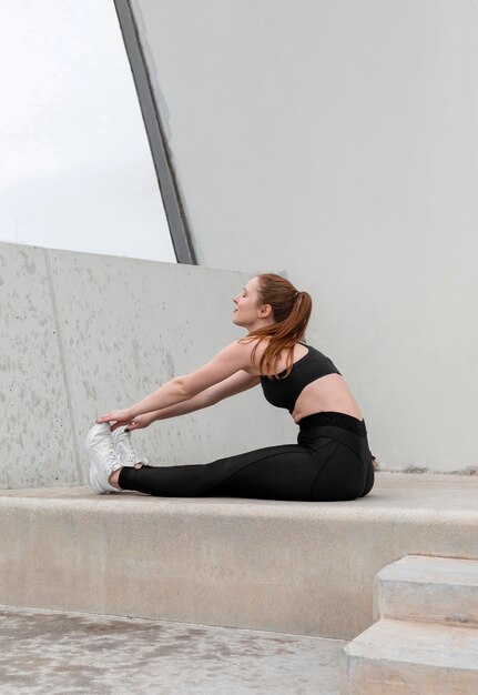 Redhead woman in sportswear exercising outdoors