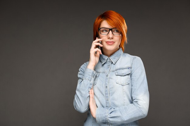 携帯電話で話している赤毛の女性